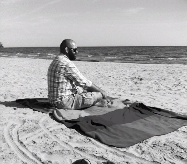 Adam Spencer on the beach, looking out over Lake Ontario